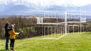 Two people stand on grass, looking at a transparent architectural sketch of a house overlaid on the landscape, discussing strategies for addressing damages, with trees and mountains in the background.