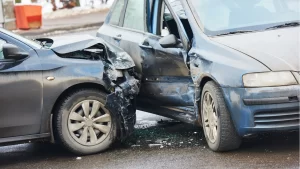 Two cars involved in a collision at an intersection, highlighting car accident mistakes with significant damage to the front of one car and the side of the other.
