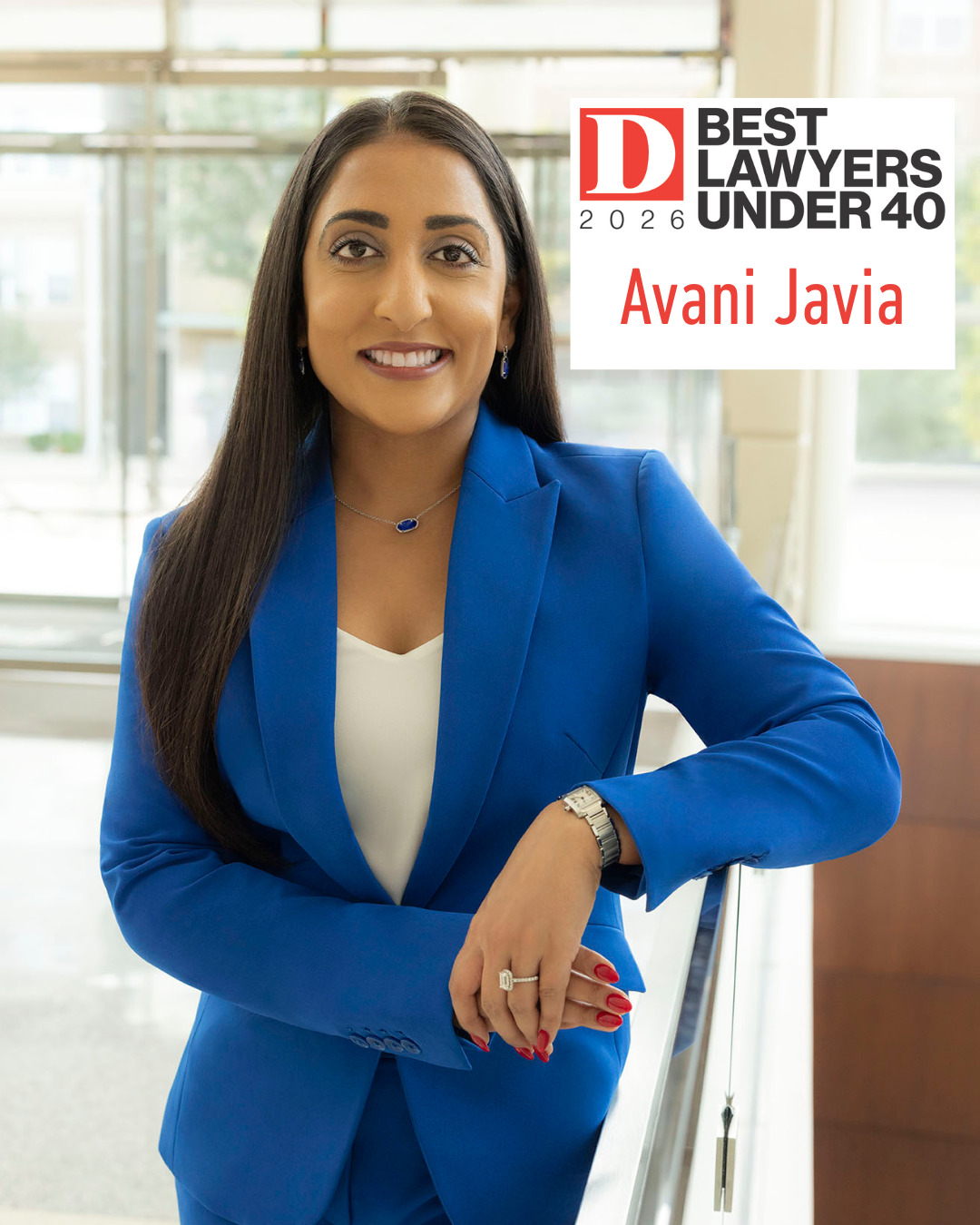 A woman in a blue suit stands indoors, smiling with arms crossed. Text reads: “Best Lawyers Under 40 2026, Avani Javia, Fears Law.”.